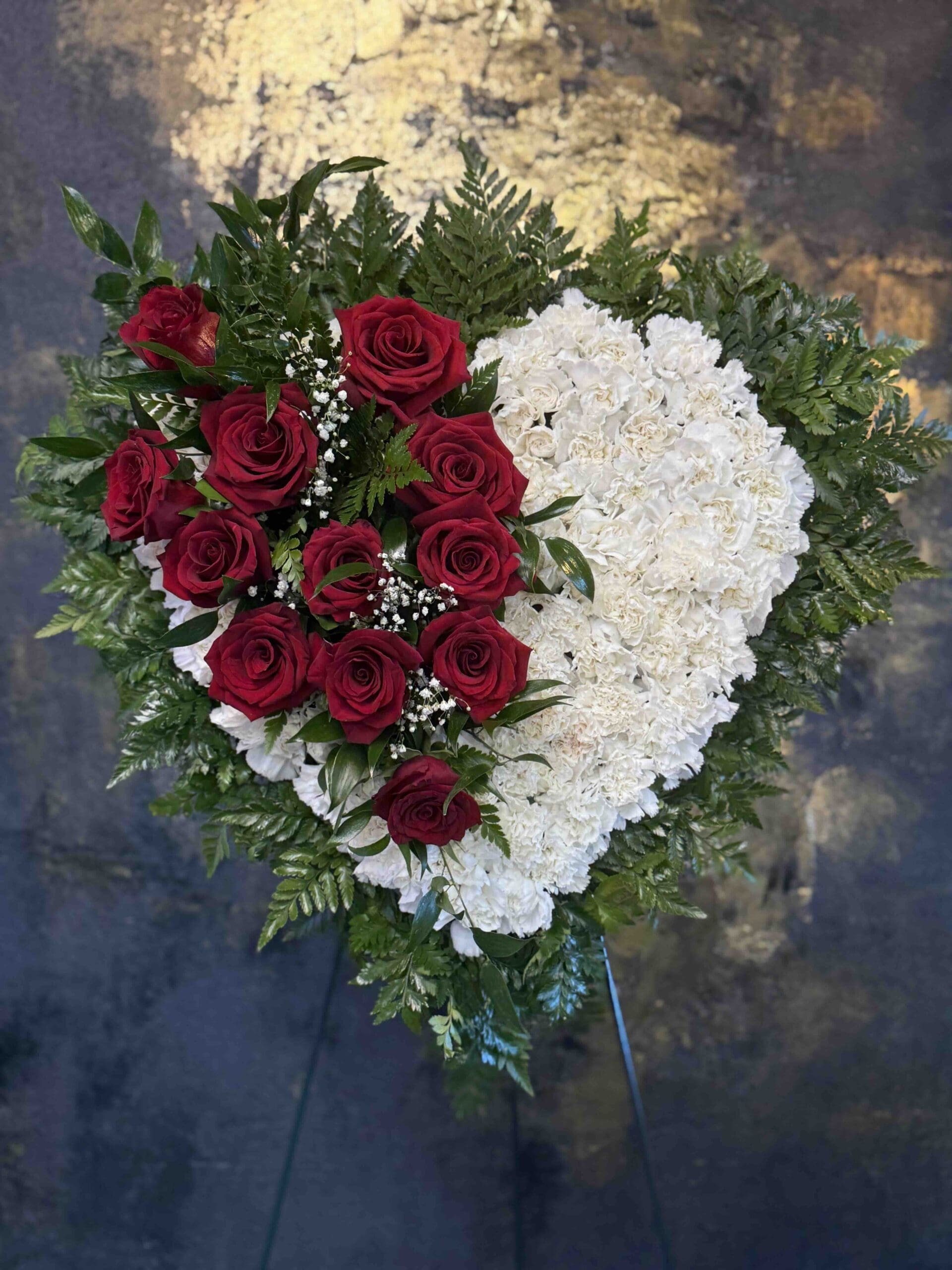Bleeding Hear Funeral Spray White carnation funeral heart with red roses and greenery in Naples Florida.