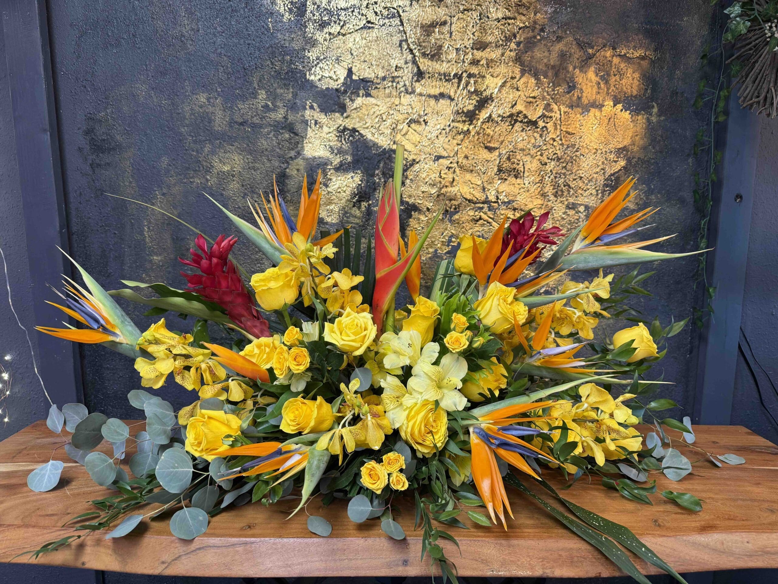 Casket Funeral Piece Luxury tropical casket spray with birds of paradise, yellow roses, orchids and tropical flowers in Naples Florida.
