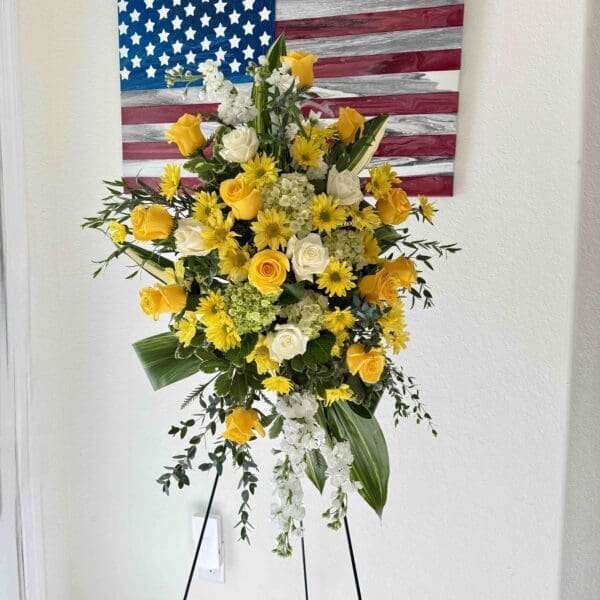 Yellow and white funeral standing spray with roses, hydrangea, stock and chrysanthemums in Naples Florida.